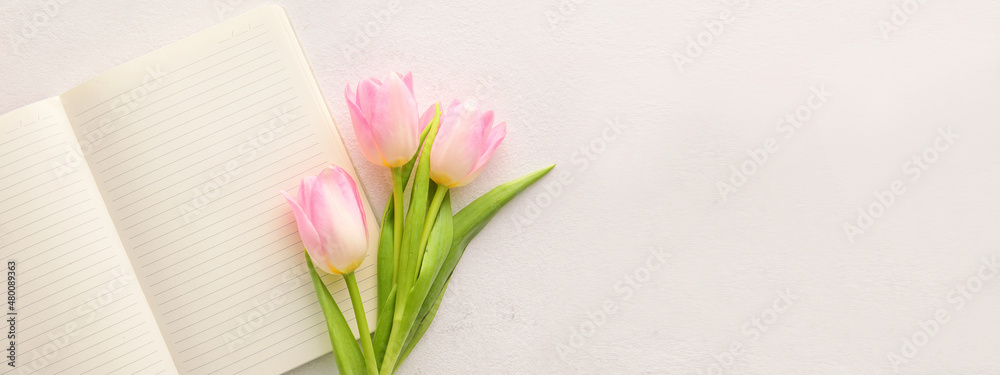 Blank notebook and tulips on light background with space for text Blank notebook and tulips on light background with space for text
