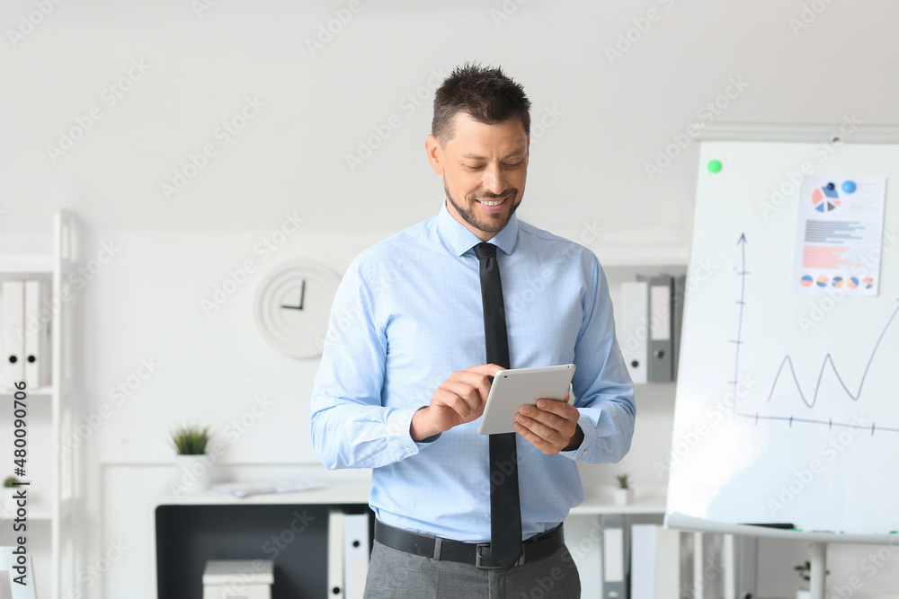 Handsome businessman using tablet computer in office