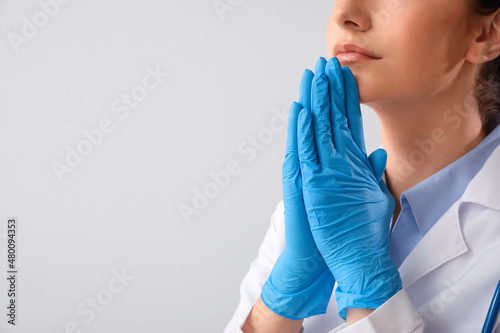 Praying female doctor on gr...