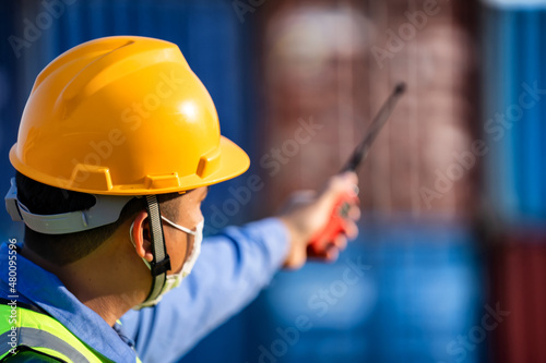 Industrial workers holding walkie talkies to coordinate.