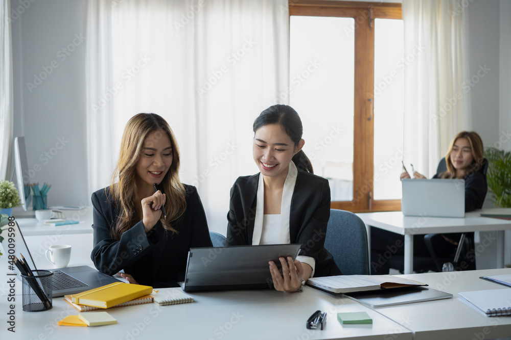 Two happy businesswomen using digital tablet and discussing new project together. Two happy businesswomen using digital tablet and discussing new project together.