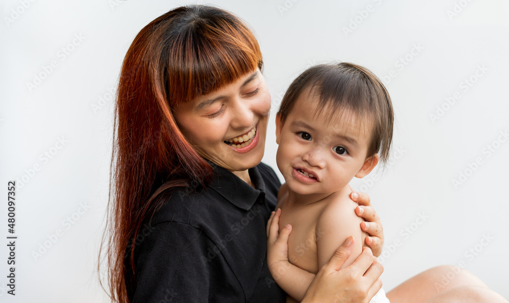 Happy mother with her baby on isolated white background. Mom wearing black shirt holding her son and smiling merrily. Young attractive happy mother smiling hugging looking at her littel baby. Happy mother with her baby on isolated white background. Mom wearing black shirt holding her son and smiling merrily. Young attractive happy mother smiling hugging looking at her littel baby.