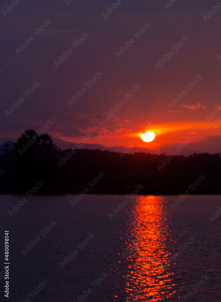 The sun was about to set in red. In front of the lake was a lake of sunlight reflecting the water. Blurred image, difficult to describe.