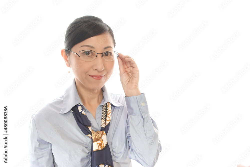眼鏡に手をやる中年女性
