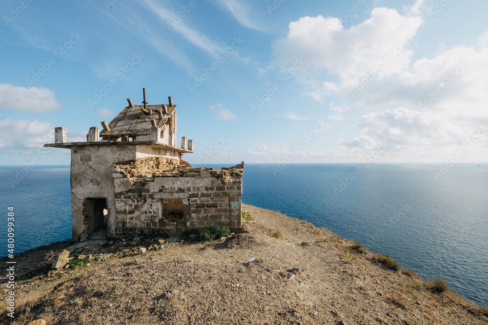 Crimea, Cape Meganom. Old building (ruins) against the blue sea and sky