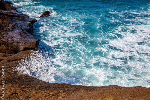 Small bay with foamy waves surrounded by stones in Tenerife