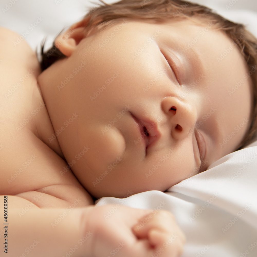 A Baby girl with Smily Face During Sleep. Little baby girl sleeping on white blanket. Beautiful portrait of little child girl 14 days, two weeks old. Motherhood A Baby girl with Smily Face During Sleep. Little baby girl sleeping on white blanket. Beautiful portrait of little child girl 14 days, two weeks old. Motherhood