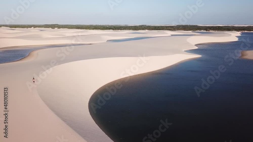 Lonely guy walking alone in the dunes of Lençóis Maranhenses National Park aerial view - One of the most beautiful places in Brazil photo