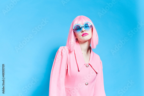 woman in pink wig and dress on blue background