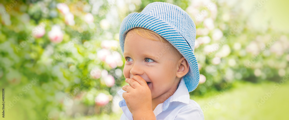 Banner with spring kids portrait. Kid summer walking in casual clothes. Happy smiling boy in spring park or garden. Banner with spring kids portrait. Kid summer walking in casual clothes. Happy smiling boy in spring park or garden.