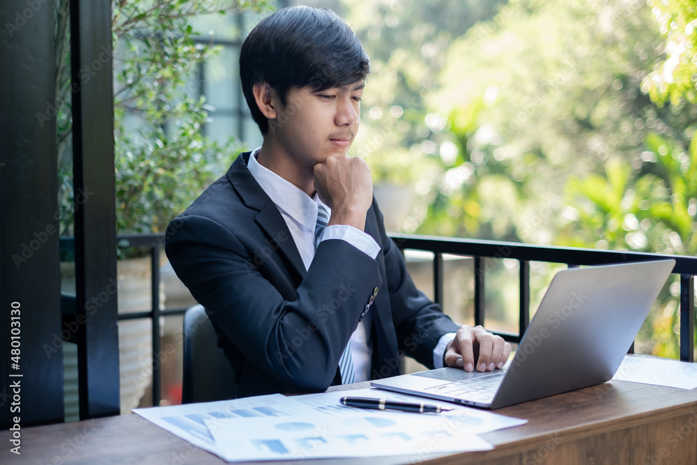 Young Asian businessman financial market analyst sits at their desks and calculate financial graphs showing the results of their investments planning the process of successful business growth Young Asian businessman financial market analyst sits at their desks and calculate financial graphs showing the results of their investments planning the process of successful business growth