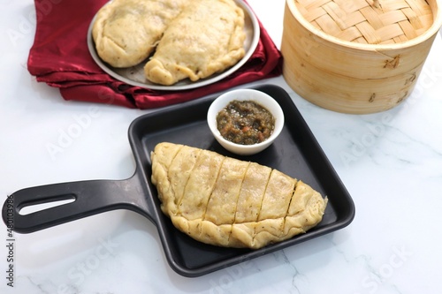 Himachali Local dish siddu. It's a steamed stuffed bread. Made from wheat flour stuffed with split urad dal, dry fruits, poppy seeds, walnut etc. and enjoyed with desi ghee, tomato chutney. Copy space photo