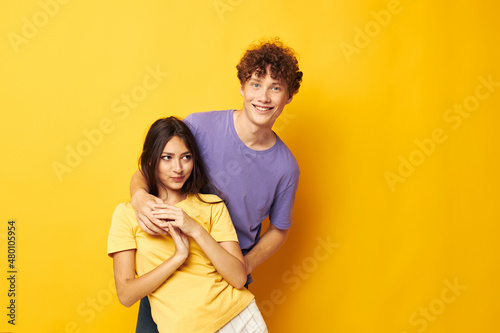 young boy and girl Friendship posing fun studio yellow background unaltered