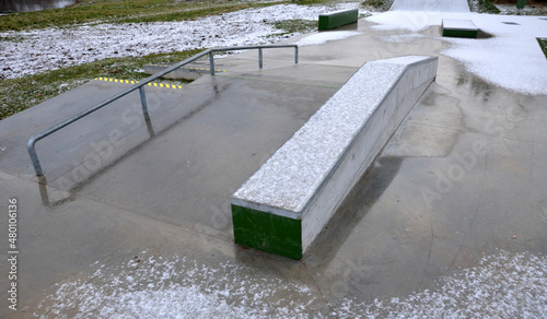 Skateboard park with concrete cement surface with concrete skateboard obstacles is designed for roller sports. Cycling is not allowed except for freestyle bikes. Protective clothing, head, elbow knee photo