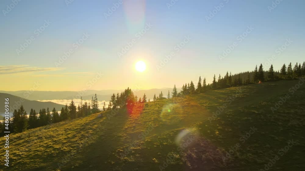 Aerial view of tourist camping tents on mountain campsite at bright sunny evening. Active tourism and hiking concept