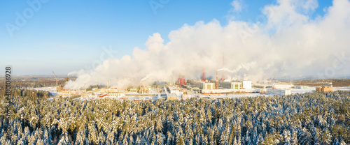 Industrial landscape. Panoramic view of the technological pipe and industrial infrastructure. Chemical production with red-white pipes and smoke is coming. Production buildings. photo