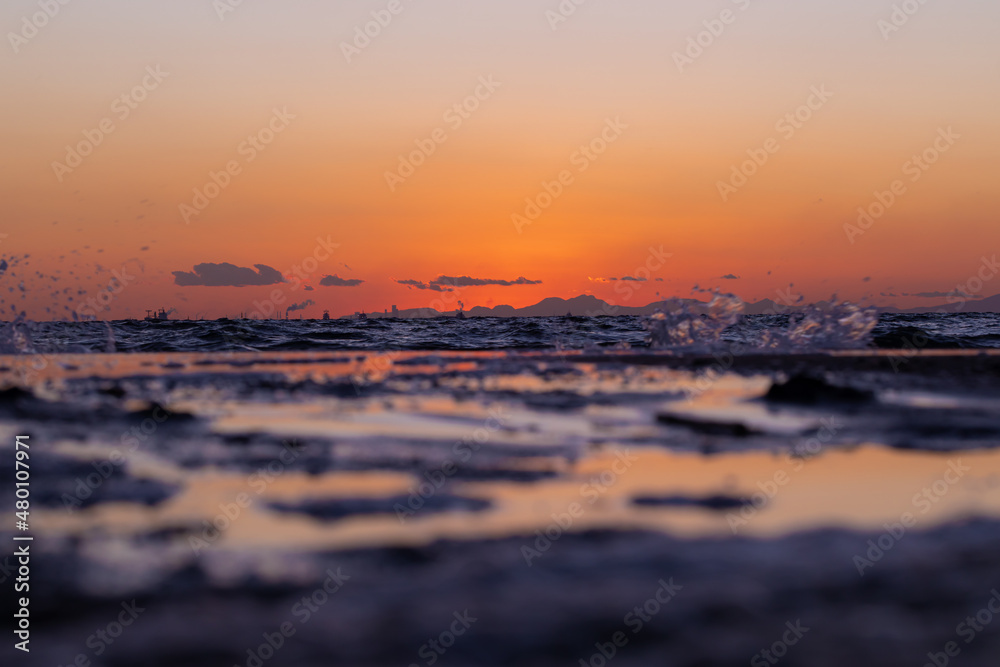 Obraz premium 赤く染まる夕陽と砂浜