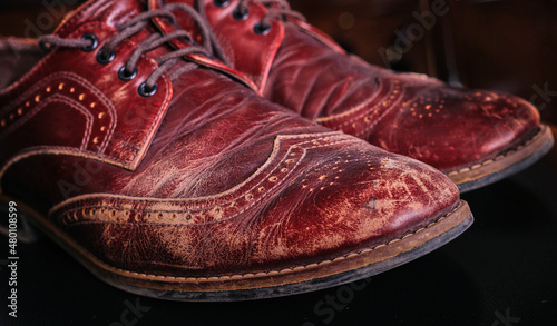 Фотография worn old leather scratches and scuffs on men oxford shoes