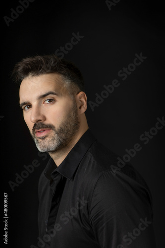 Portrait of a handsome man with beard on black background