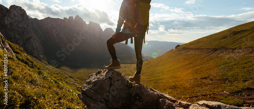 Solo woman backpacker hiking on alpine mountain peak