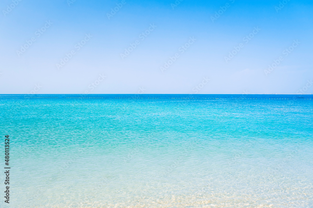 Beautiful beach in sunny summer day. Turquoise ocean water and blue sky with clouds . Natural background for summer vacation, soft focus, space for text