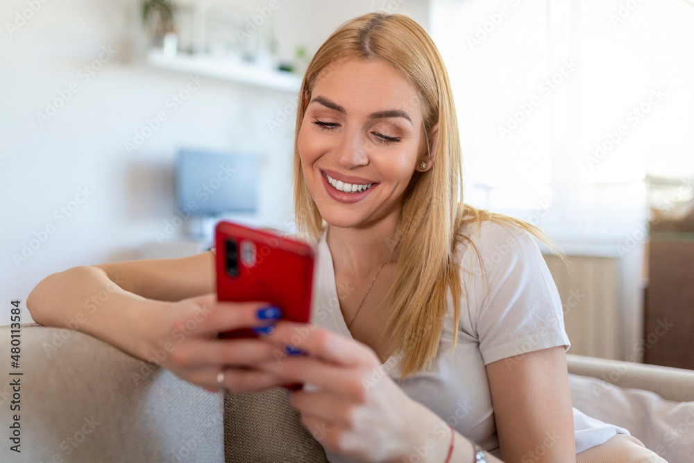 Young woman sit relax on sofa in living room browsing surfing wireless internet on smartphone, millennial girl rest on couch at home message text on modern cellphone, shopping online via website Young woman sit relax on sofa in living room browsing surfing wireless internet on smartphone, millennial girl rest on couch at home message text on modern cellphone, shopping online via website