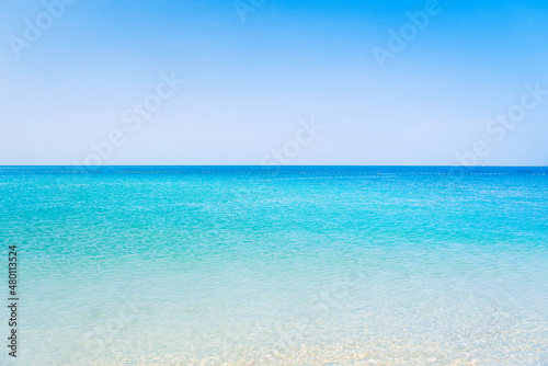 Fototapeta Naklejka Na Ścianę i Meble -  Beautiful beach in sunny summer day. Turquoise ocean water and blue sky with clouds . Natural background for summer vacation, soft focus, space for text
