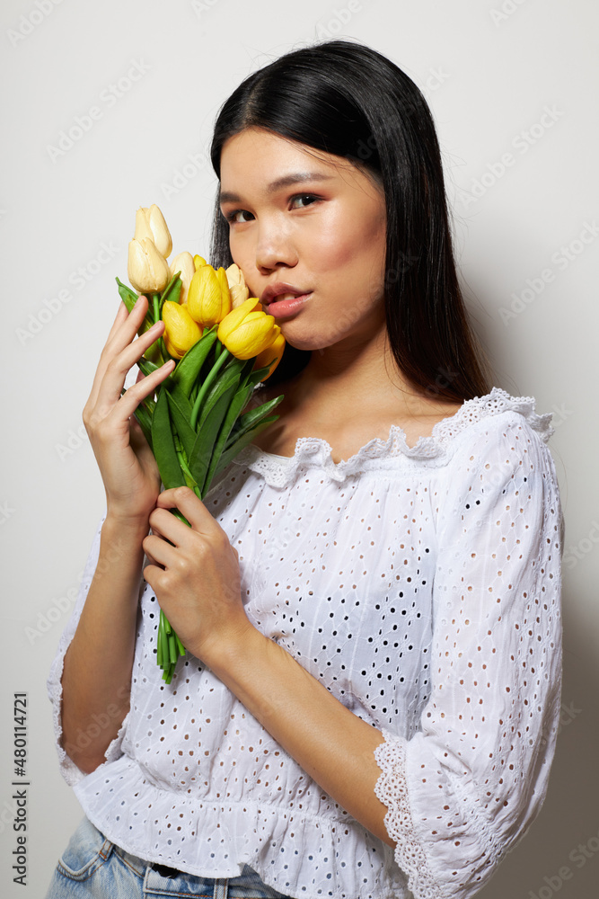Portrait Asian beautiful young woman romance bouquet of flowers near the face light background unaltered Portrait Asian beautiful young woman romance bouquet of flowers near the face light background unaltered