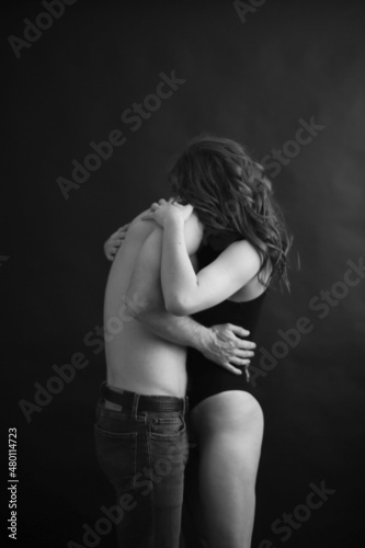 Sensual touches between a man and a woman, a beautiful fashion portrait of a couple, body details with a slight element of eroticism. A place for text and a blurred fleur of love
