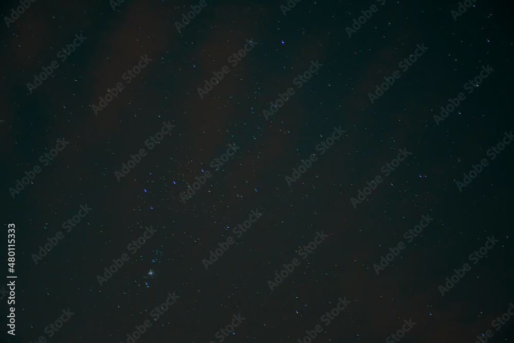 Blurry night sky and Orion Constellation. Black wallpaper with universe concept. M42 nebula visible in the evening. No selective focus, defocused background.
