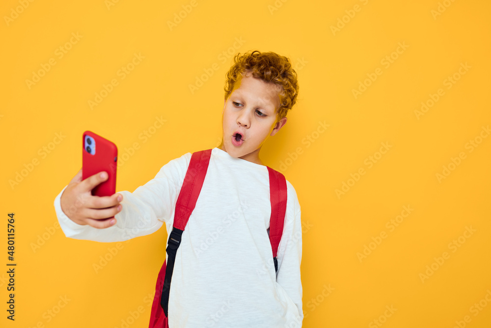 smiling little boy in white sweatshirt mobile cell phone red backpack Studio smiling little boy in white sweatshirt mobile cell phone red backpack Studio