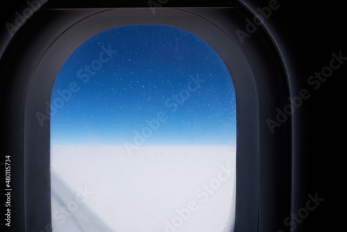 Window in an Aircraft in flight, dark background, blue sky