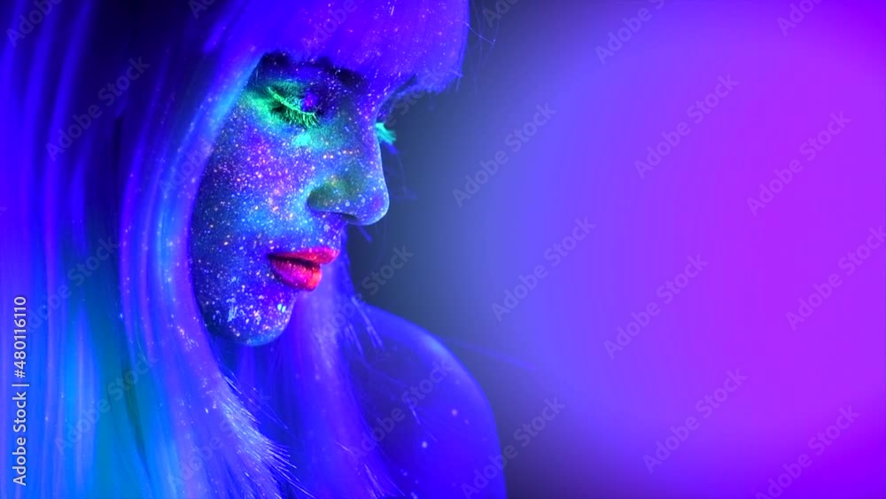 Fashion model woman in neon light, beautiful model girl colorful bright fluorescent make-up, painted skin, Body Art design of disco female in UV, colorful make up. Night club. 4K UHD video footage