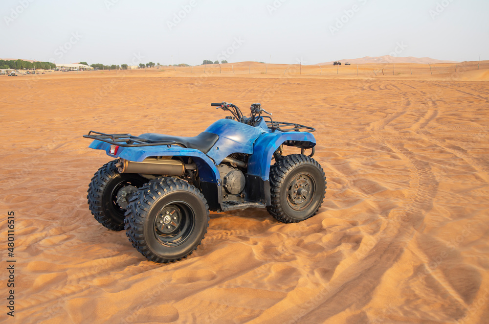 Powerful modern ATV sand among the Arabian sand dunes. Quad bike, The Rub al-Khali Desert in Dubai Powerful modern ATV sand among the Arabian sand dunes. Quad bike, The Rub al-Khali Desert in Dubai