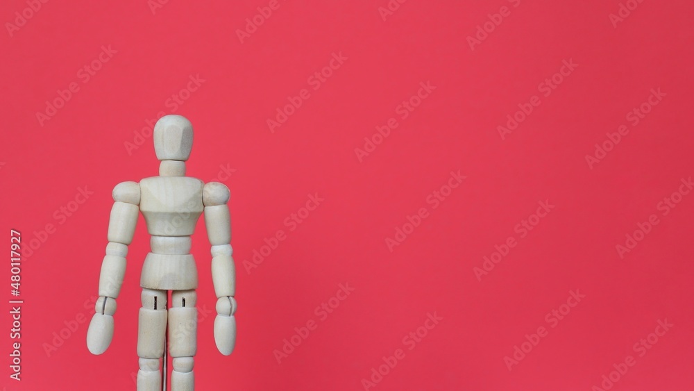 Close up image of wooden doll on red background with copy space. Close up image of wooden doll on red background with copy space.