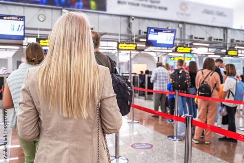 Photography Rear view of an airline passenger waiting to check in at passport control at the airport