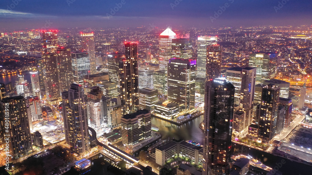 Aerial drone night shot of iconic illuminated with Christmas lights skyscraper banking and business complex of Canary Wharf, Docklands, London, United Kingdom