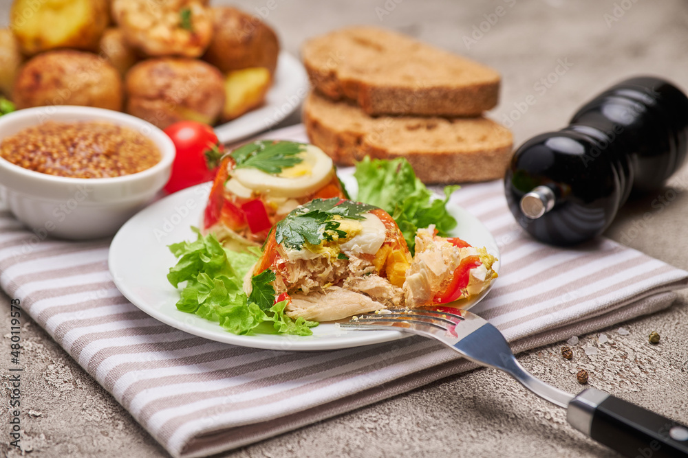 Portion of delicious chicken aspic on a plate isolated on concrete table Portion of delicious chicken aspic on a plate isolated on concrete table