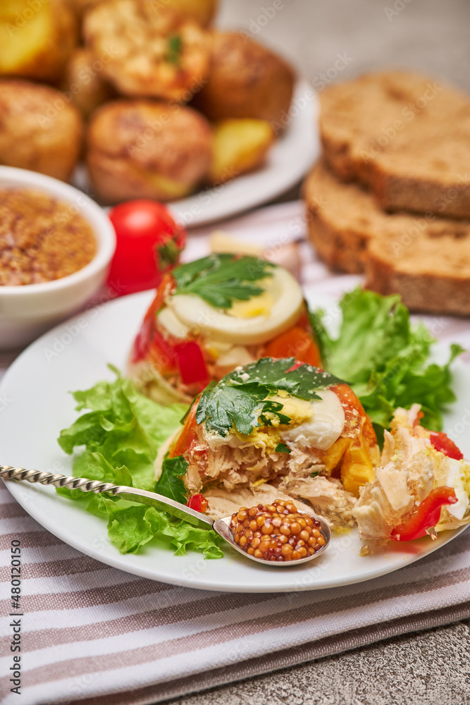 Portion of delicious chicken aspic on a plate isolated on concrete table Portion of delicious chicken aspic on a plate isolated on concrete table