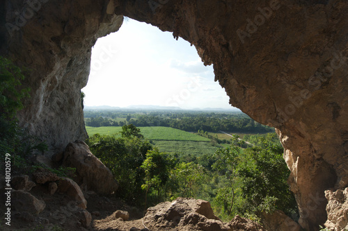 Mountain view through the hole in the cave © akachai studio