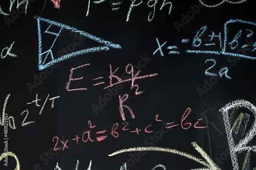 school blackboard with chalk-drawn drawings and formulas.