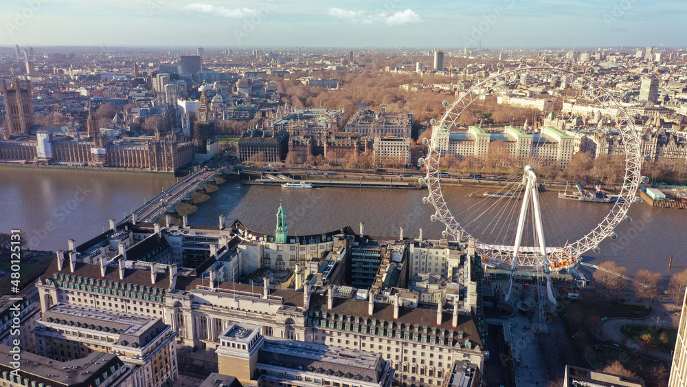 Aerial drone photo of iconic giant Ferris Wheel of London eye in front of river Thames and houses of Parliament and Big Ben at the background, Westminster, United Kingdom