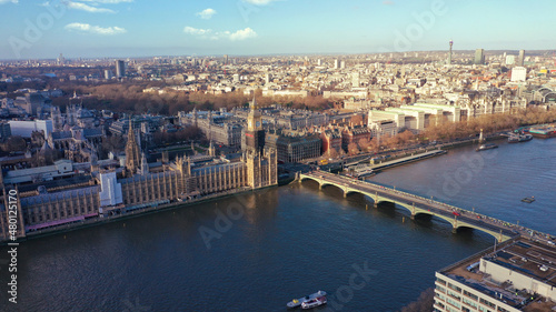 Aerial drone photo of iconic City of Westminster with houses of Parliament, Big Ben and Westminster Abbey in front of river Thames, London, United Kingdom © aerial-drone