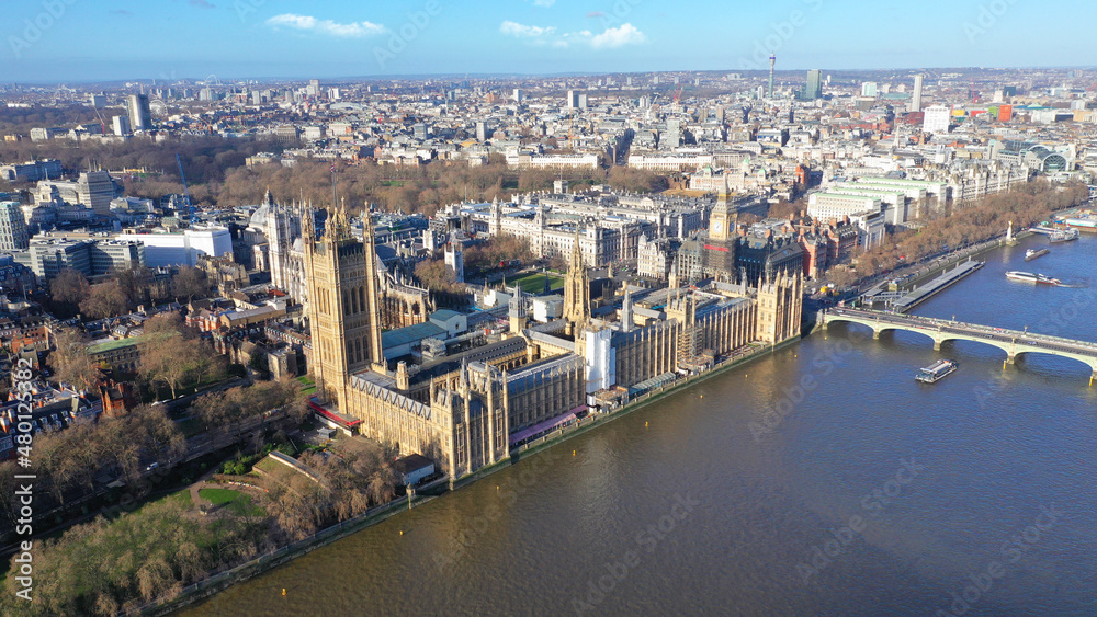 Aerial drone photo of iconic City of Westminster with houses of Parliament, Big Ben and Westminster Abbey in front of river Thames at sunset, London, United Kingdom