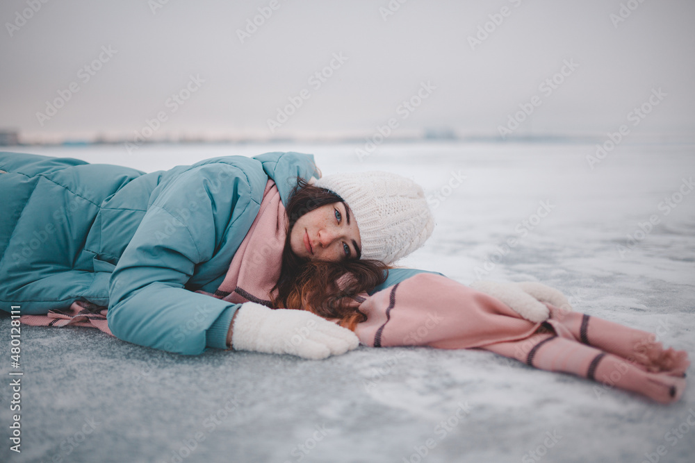 beautiful young girl lying on ice, frozen lake, girl lying in snow beautiful young girl lying on ice, frozen lake, girl lying in snow