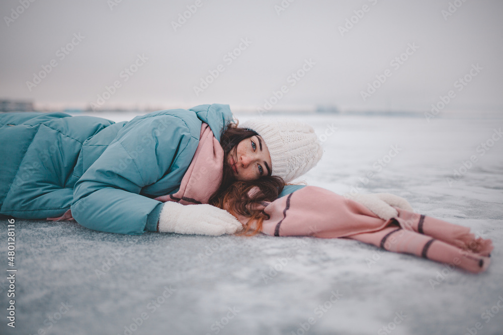 beautiful young girl lying on ice, frozen lake, girl lying in snow beautiful young girl lying on ice, frozen lake, girl lying in snow