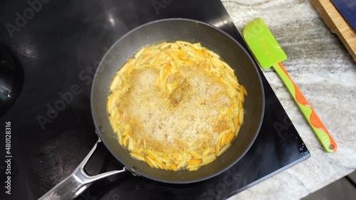 Wallpaper Mural frying pan on a ceramic hob with evaporating slices of orange citrus peel for making sauce for meat  Torontodigital.ca