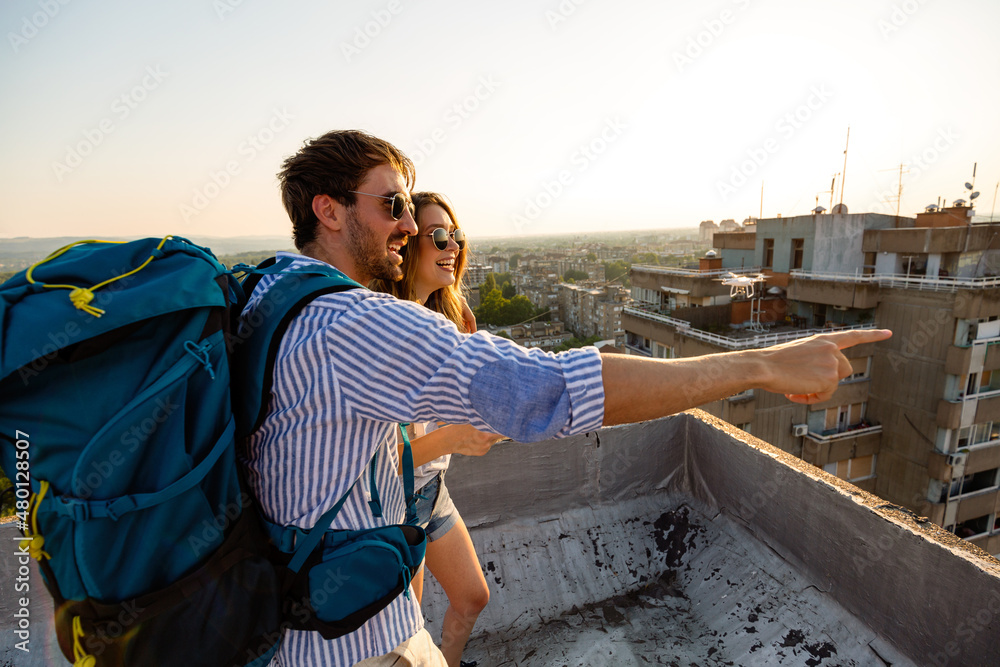 Happy tourist couple, friends sightseeing city with map. Travel people vacation concept