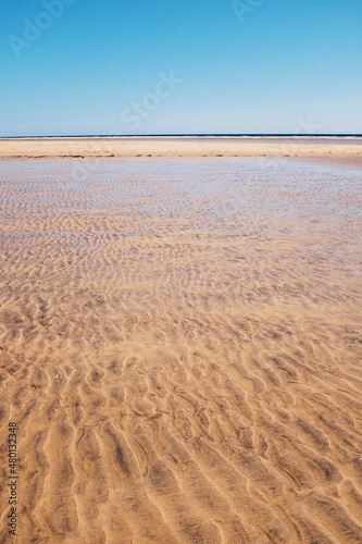 Sand and beach landscape with transparent clean tropical ocean water. Blue sky in background. Concept of summer travel holiday vacation inscenic place