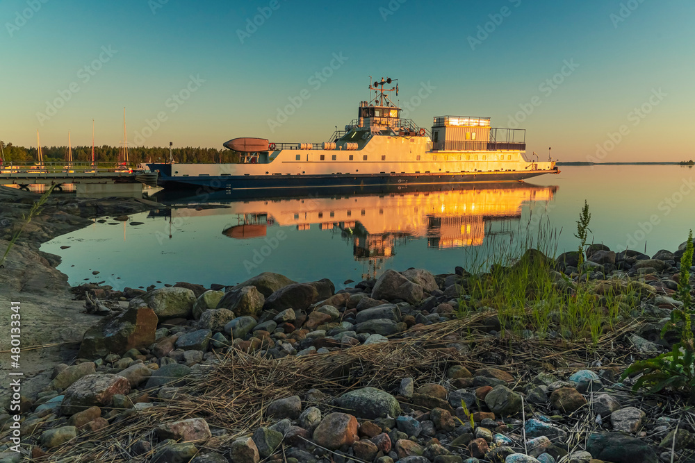Ferry at the pier. Early, summer dawn. Nature of Scandinavia. Islands in the sea. Finland.